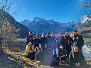 Ein Foto der Gruppe, die am Winterseminar mit war, vor einem Bergsee. Im Hintergrund erkennt man die Berge.